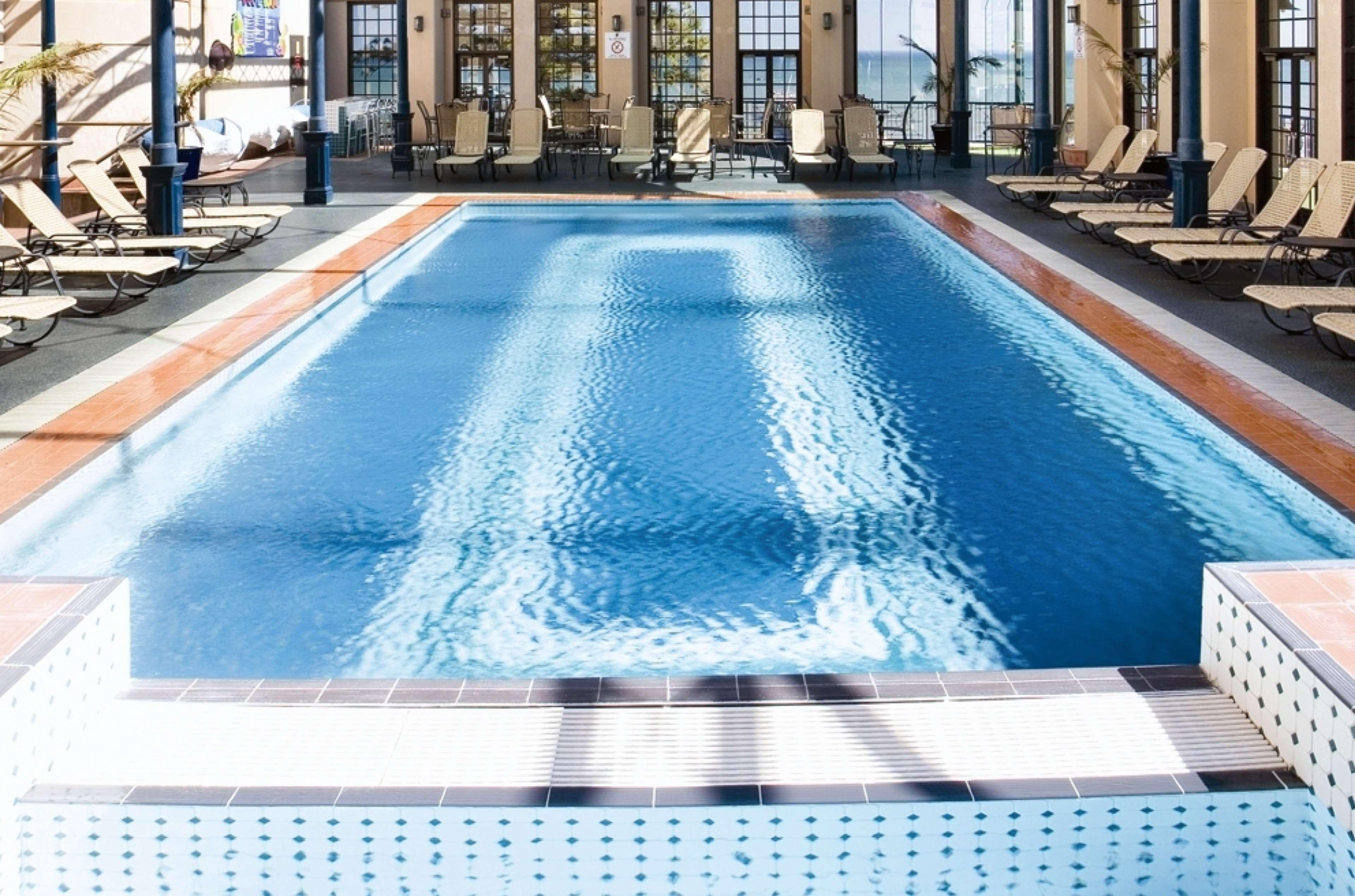Hotel Stamford Grand Adelaide Glenelg Exterior foto The photo shows an indoor swimming pool with a pristine blue surface. The pool is surrounded by a tiled deck and has lounge chairs lined up along the sides. Large windows allow natural light to flood the area, creating a bright and inviting atmospher