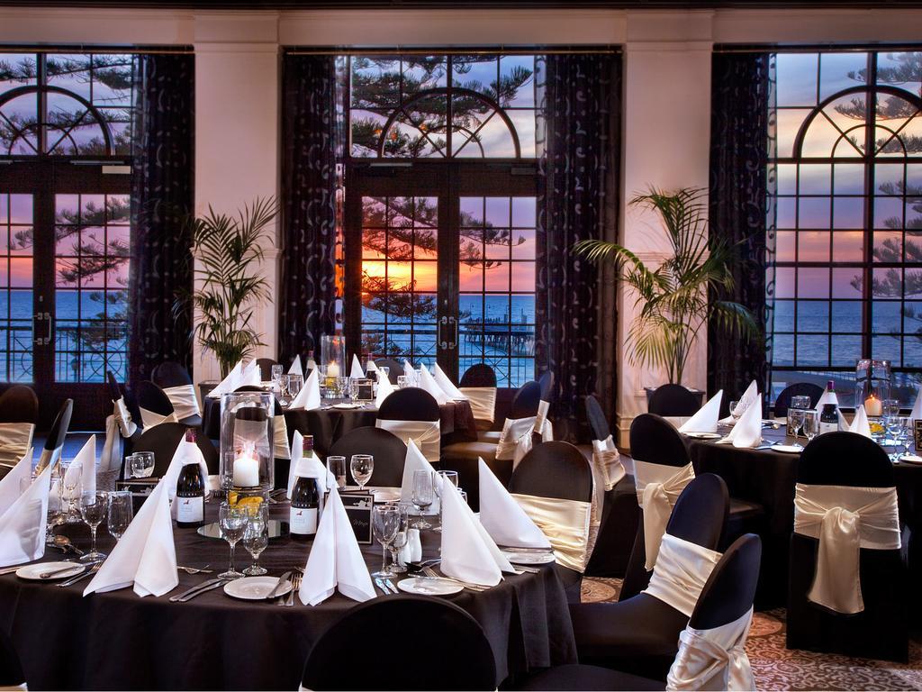 Hotel Stamford Grand Adelaide Glenelg Exterior foto The photo shows an elegant dining setup inside a venue with large windows. The tables are adorned with black tablecloths and white napkins arranged in a stylish manner. Each table has glassware and other dining utensils placed neatly. In the backgrou